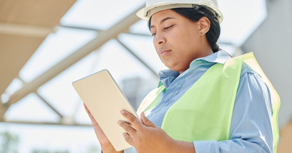 Gestionnaire de chantier avec tablette et plans