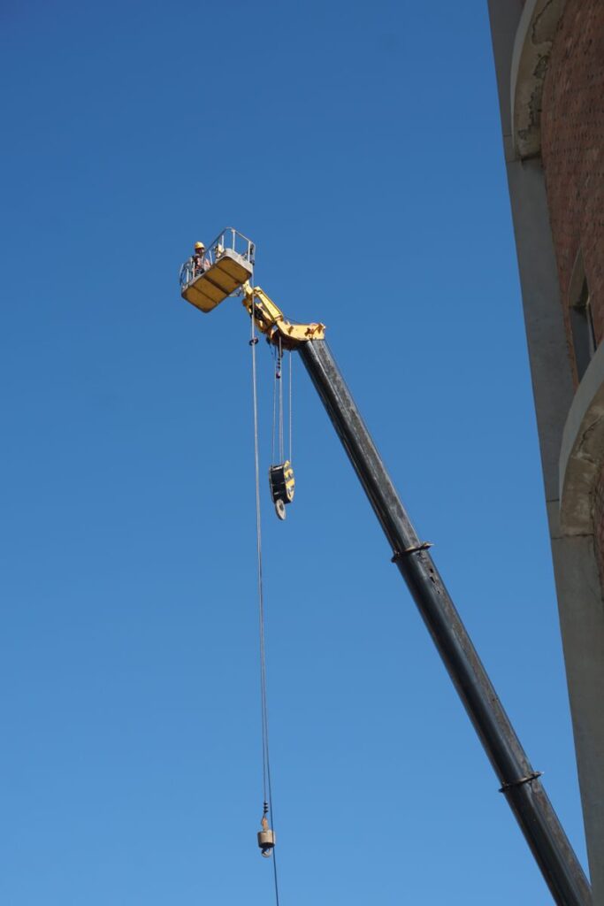Grue de chantier avec opérateur sur fond de ciel bleu