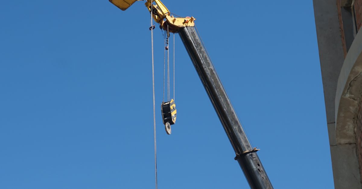 Grue de chantier avec opérateur sur fond de ciel bleu