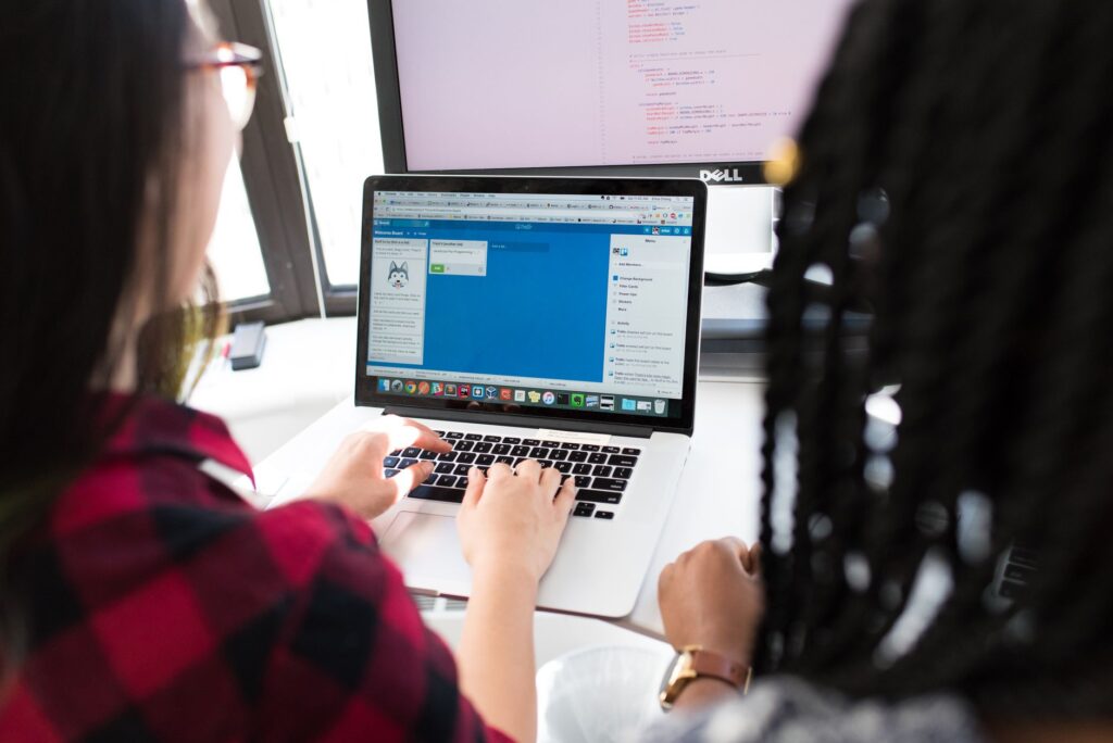 Deux développeurs collaborent devant un écran de code dans un bureau