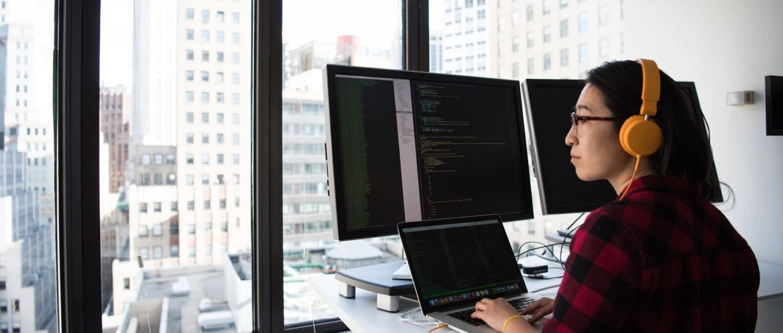 Un développeur réfléchit devant son ordinateur portable dans un bureau lumineux
